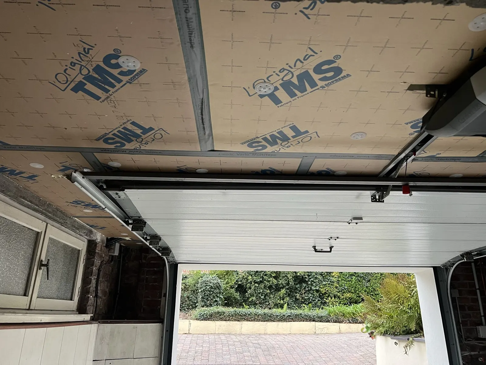 après l'isolation du plancher bas à Faumont : panneaux TMS au plafond du garage, porte sectionnelle et son moteur